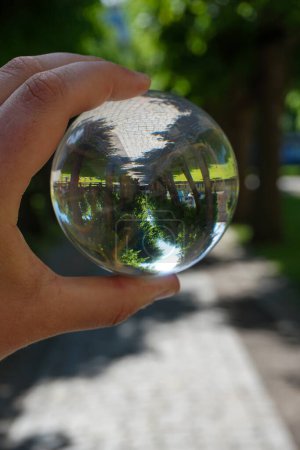 Mano recortada sosteniendo una bola de cristal al aire libre 