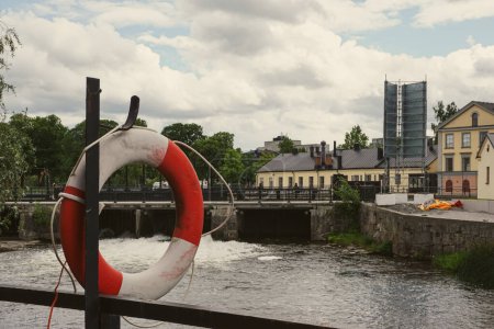 close-up of a lifebuoy by the river in the city