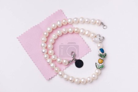 Photo for Pearls string and jewelry polishing cloth - Royalty Free Image