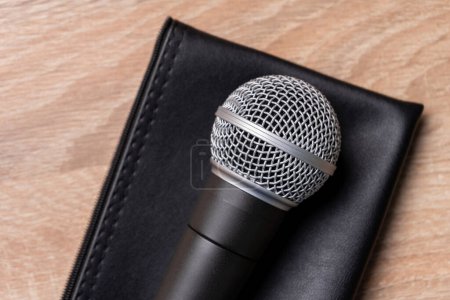 Téléchargez les photos : Microphone dynamique noir sur étui en cuir noir - en image libre de droit