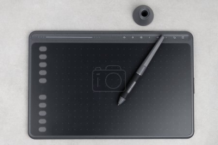 Photo for Top view of drawing tablet and stylus on grey background - Royalty Free Image
