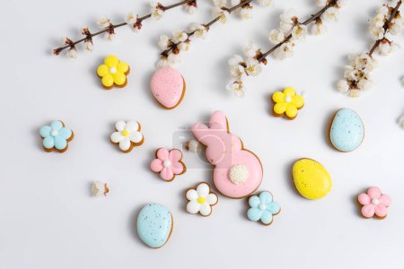 Easter cookies and cherry blooming branches on white background