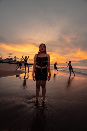 Photo for Portrait of an Asian woman in black clothes standing on the beach with a very sad expression in the morning - Royalty Free Image