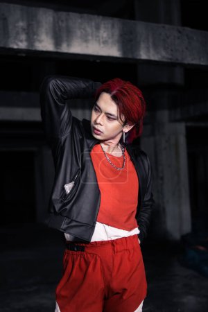Photo for An asian man with red hair and a black jacket is posing in an abandoned building at night - Royalty Free Image