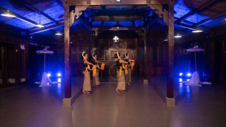Photo for A group of Javanese dancers dances in a gazebo with brown wood at night - Royalty Free Image