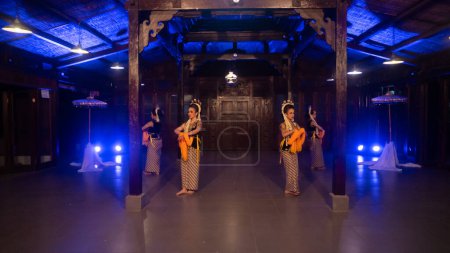 Photo for A group of Javanese dancers dances in a gazebo with brown wood at night - Royalty Free Image