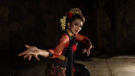 Photo for A Javanese dancer dressed in traditional red clothes enchanted the audience with her graceful movements that blended with the melody of the night - Royalty Free Image