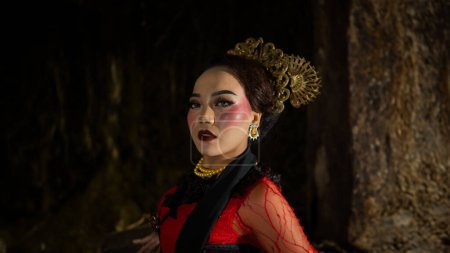 Photo for A Javanese dancer dressed in traditional red clothes enchanted the audience with her graceful movements that blended with the melody of the night - Royalty Free Image