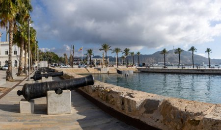 Photo for Historic Canons at the harbour of Cartagena, Spain near the Whale tail sculpture and palm trees in the background - Royalty Free Image
