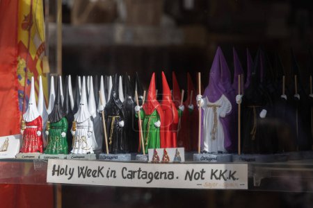 Photo for Small toy figures in window shop of figurines with hoods over their heads for a traditional festival. Sign reads Holy week in Cartagena, Not KKK - Royalty Free Image