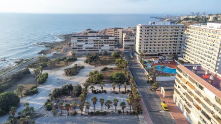 Aerial photo of apartments and swimming pool by the sea and cliffs of Cabo Cervera in Torrevieja