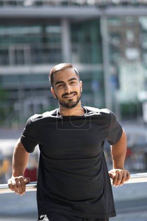 Photo for Vertical portrait of smiling middle eastern confident man smiling and looking at camera on the street. People and emotions concept - Royalty Free Image
