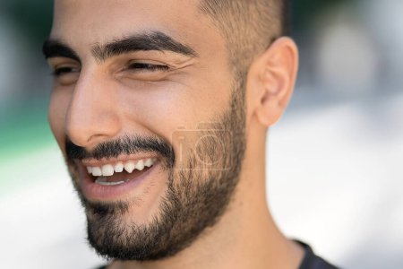 Téléchargez les photos : Portrait de l'homme heureux iranien confiant riant et regardant loin dans la rue. Concept des personnes et des émotions - en image libre de droit