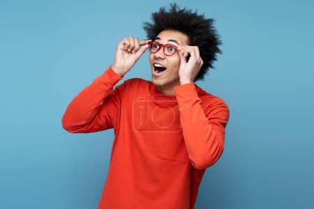 Photo for Young excited stylish African American man wearing stylish eyeglasses looking away isolated on blue background, copy space. Vision concept - Royalty Free Image