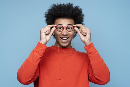 Photo for Portrait of attractive funny African American man wearing stylish isolated on blue background, vision concept. Young smiling nerd student looking at camera, education. Studio shot - Royalty Free Image