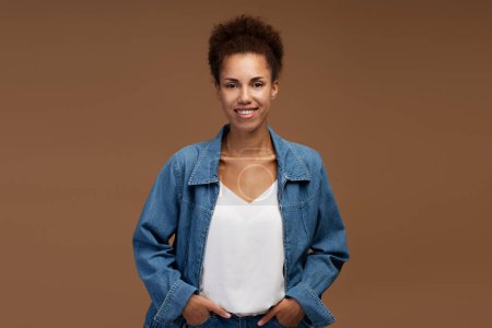 Photo for Portrait of smiling confident African American business woman looking at camera isolated on brown background. Successful business concept - Royalty Free Image