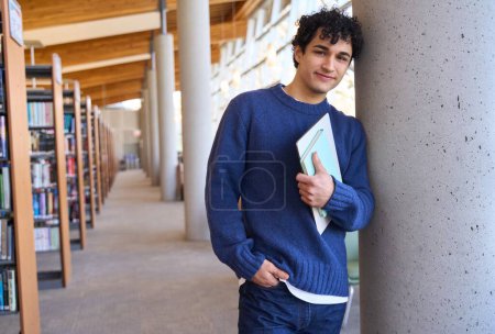 Photo for Confident portrait of a handsome Latin American young man, smart student with laptop and notebook, in the university library campus. Erudite Educated people, learning, knowledge and education concept - Royalty Free Image