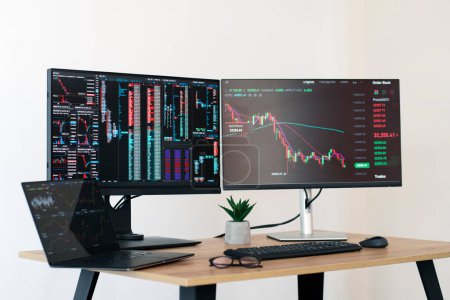 Photo for Computer monitors, laptop with trader charts on the desk. Trader workplace concept - Royalty Free Image