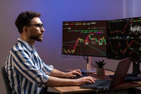 Pensive successful trader working with crypto chart, analyzing stock market, working in modern office. Online trading concept  