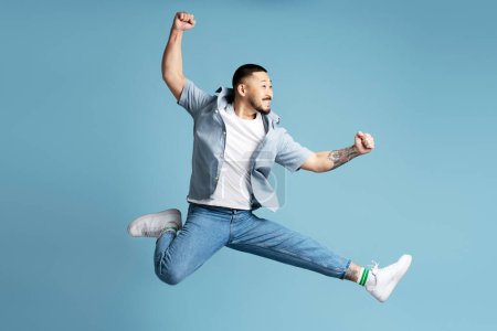 Téléchargez les photos : Asiatique homme portant des vêtements décontractés élégants, chaussures blanches courir vite, sauter haut isolé sur bleu - en image libre de droit