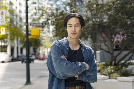 Photo for Portrait of handsome confident Japanese man holding arms crossed wearing stylish casual outfit looking at camera standing on the street. Beauty concept - Royalty Free Image