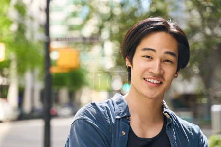 Photo for Closeup portrait of confident handsome Japanese man with stylish hair walking on the street, copy space. Smiling asian student standing in university campus, education concept - Royalty Free Image