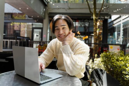 Photo for Handsome asian freelancer working online, sitting at desk, using laptop, in modern office. Portrait of young japanese student studying, preparing for exam, online education concept - Royalty Free Image