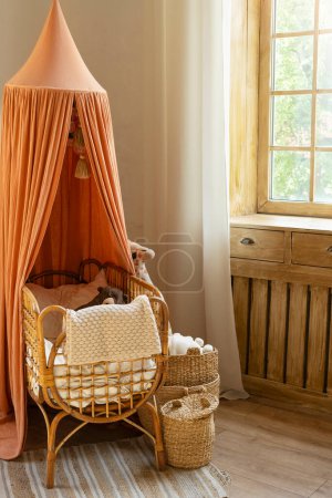 Foto de Interior del dormitorio de bebé con una acogedora cama de madera, cestas de mimbre y juguetes de estilo moderno y sencillo. Habitación unisex para niño - Imagen libre de derechos