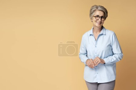 Téléchargez les photos : Portrait de femme d'affaires aux cheveux gris souriant portant des lunettes isolées sur fond - en image libre de droit