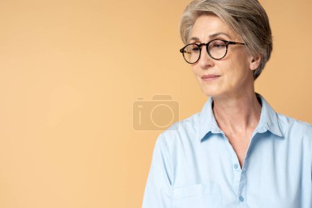Foto de Retrato de mujer de pelo gris senior con anteojos aislados en el fondo, espacio de copia. Visión - Imagen libre de derechos