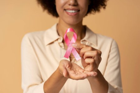 Photo for African American woman holding pink ribbon isolated on background. Breast cancer awareness month - Royalty Free Image
