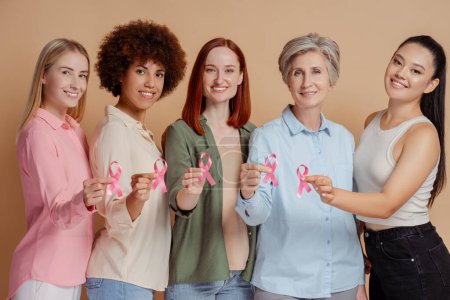 Photo for Group of smiling women holding pink ribbon. Health care, support. Breast cancer awareness month - Royalty Free Image