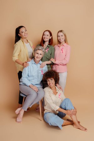 Group of women wearing pink ribbon isolated on background. Health care. Breast cancer awareness