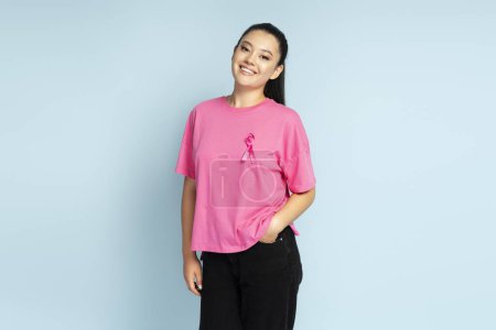Téléchargez les photos : Femme asiatique souriante avec un ruban rose cancer du sein isolé sur le fond. Sensibilisation au cancer du sein - en image libre de droit