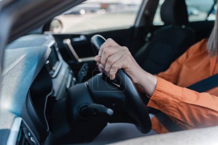 Photo for Selective focus on female driver hands on the steering wheel while driving car. Road insurance. Modern people and transport concept. Urban lifestyles - Royalty Free Image