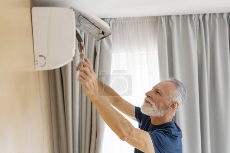 Téléchargez les photos : Réparateur principal nettoyage climatiseur, enlever le filtre sale à la maison - en image libre de droit
