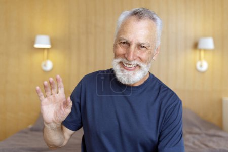 Photo for Handsome smiling senior man, freelancer waving hand having video call, working online from home. Remote job concept - Royalty Free Image