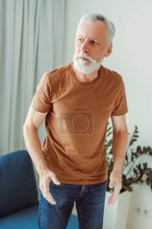 Téléchargez les photos : Portrait d'un homme âgé aux cheveux gris solitaire regardant ailleurs dans une maison de soins infirmiers - en image libre de droit