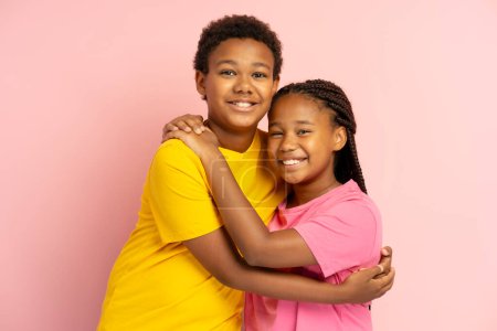 Téléchargez les photos : Frère et sœur afro-américains souriants portant un t-shirt coloré s'embrassant. Amitié - en image libre de droit