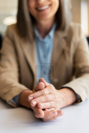 Téléchargez les photos : Gros plan de souriantes mains de femme d'affaires applaudissements assis dans le bureau moderne - en image libre de droit