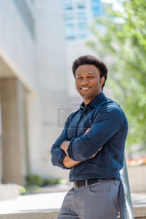Photo for Vertical view of handsome smiling businessman, CEO holding arms crossed looking at camera standing on the street, copy space. Successful business, career concept - Royalty Free Image