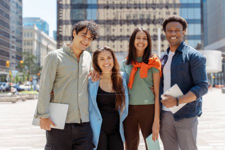 Photo for Group of multiethnic students smiling looking at camera on street near university campus. Smiling friends outdoors - Royalty Free Image