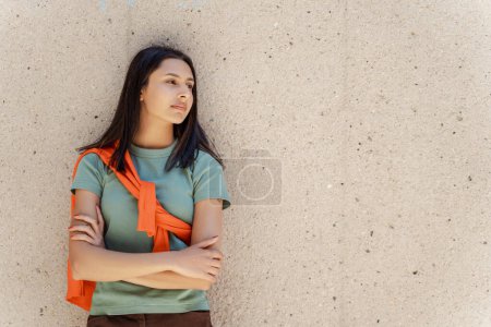 Photo for Portrait of beautiful confident Indian student looking away, standing arms crossed outdoors. Successful smiling asian woman posing near the wall, education concept - Royalty Free Image
