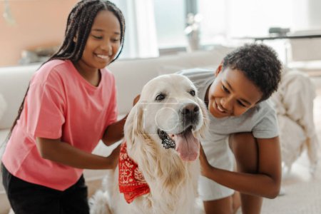 Photo for Portrait of happy children, African American brother and sister stroking and playing with golden retriever at home. Cute kids having fun with best friend. Pet love concept - Royalty Free Image
