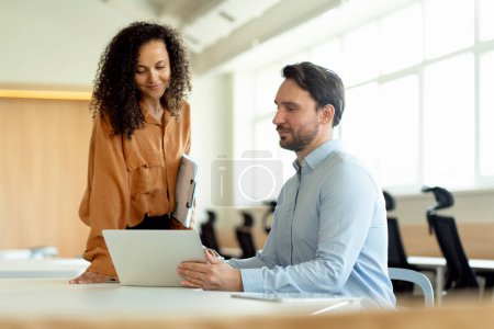 Photo for Portrait of positive businesspeople African American woman and hispanic man, using laptop, sitting at workplace in modern office. Concept of successful business - Royalty Free Image