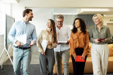 Photo for Group smiling confident business people, colleagues talking, coworkers planning startup walking in modern office. Successful business, diversity concept - Royalty Free Image