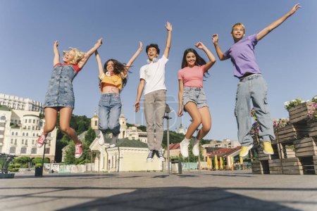 Photo for Group of multiracial overjoyed friends, happy teenagers jumping high, having fun, Happy girl and boys celebration summer holidays on the street. Friendship, positive lifestyle, summer concept - Royalty Free Image