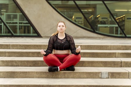 Photo for Lady meditating with eyes closed on the steps. Outdoor workout. Healthy active lifestyle concept - Royalty Free Image