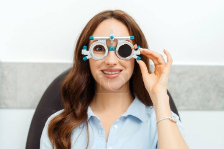 Téléchargez les photos : Examen oculaire par ophtalmologiste cadre de lunettes de test pour jeune femme. Soins de santé, médecine, concept humain - en image libre de droit