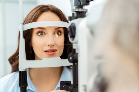 Foto de Paciente femenina en clínica de oftalmología revisando su vista. Examen médico - Imagen libre de derechos